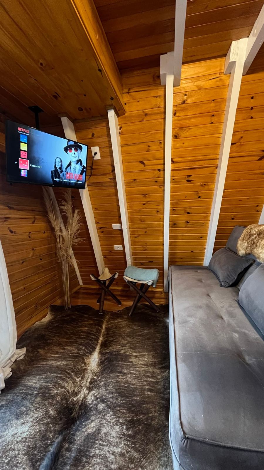 Sala com sofá-cama e TV na Cabana Nascer do Sol