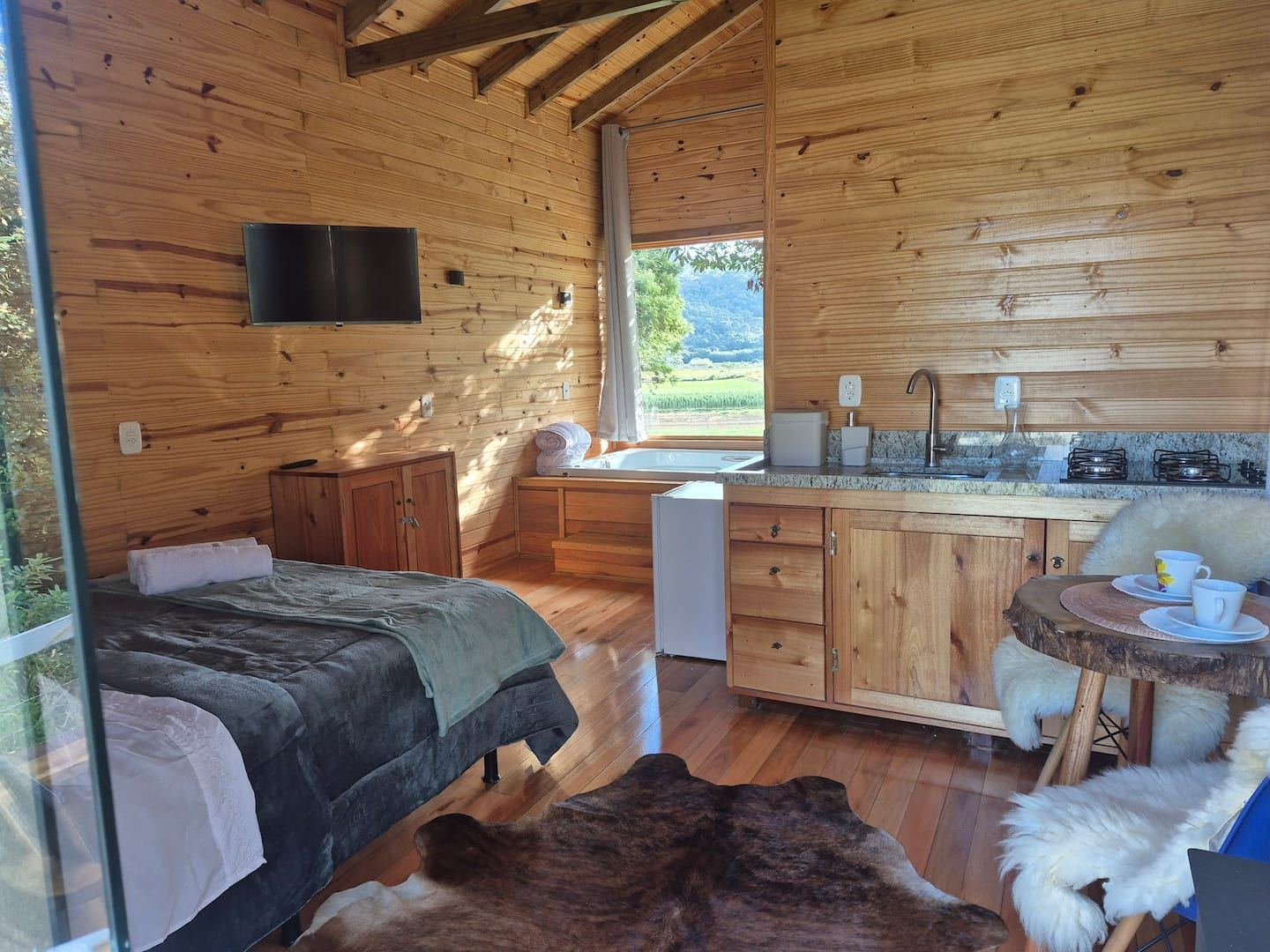 Interior integrado com cozinha e quarto na Cabana Pôr do Sol