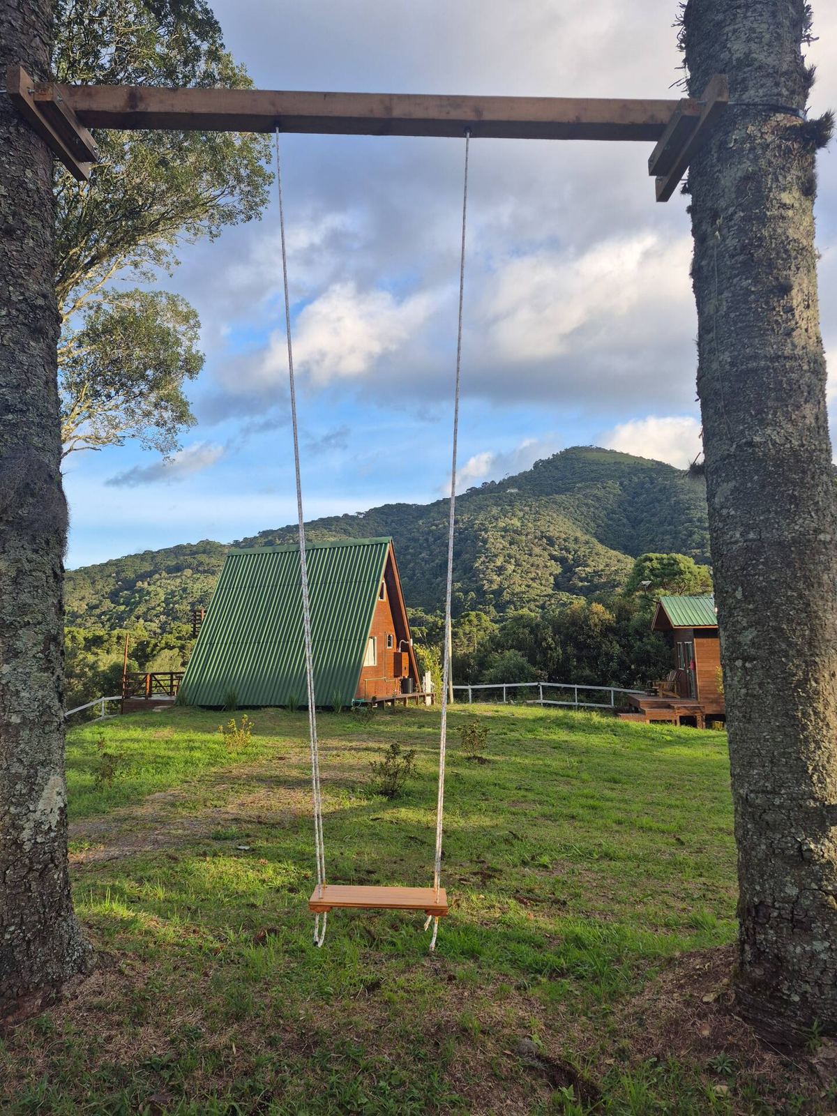 Balanço de madeira em frente às montanhas